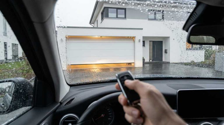 Fahrer öffnet Garagentor elektrisch mit Fernbedienung bei Regen in Waiblingen